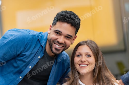 Preview: Smiling man and woman pose together indoors.
