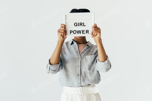 Preview: obscured view of african american woman with girl power in hands board isolated on grey