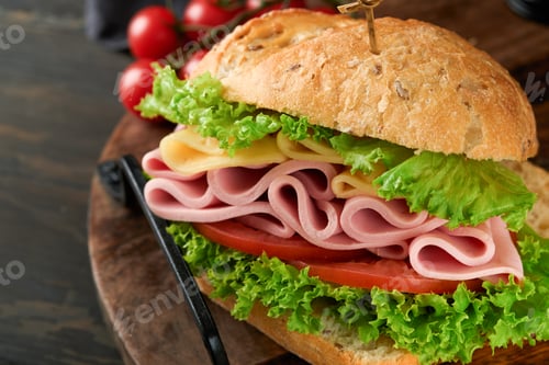 Preview: Sandwich. Tasty sandwich with ham or bacon, cheese, tomatoes, lettuce and grain bread on dark backgr
