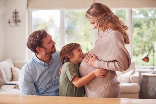 Preview: Family With Boy Hugging Pregnant Mothers Stomach As She Stands Next To Him
