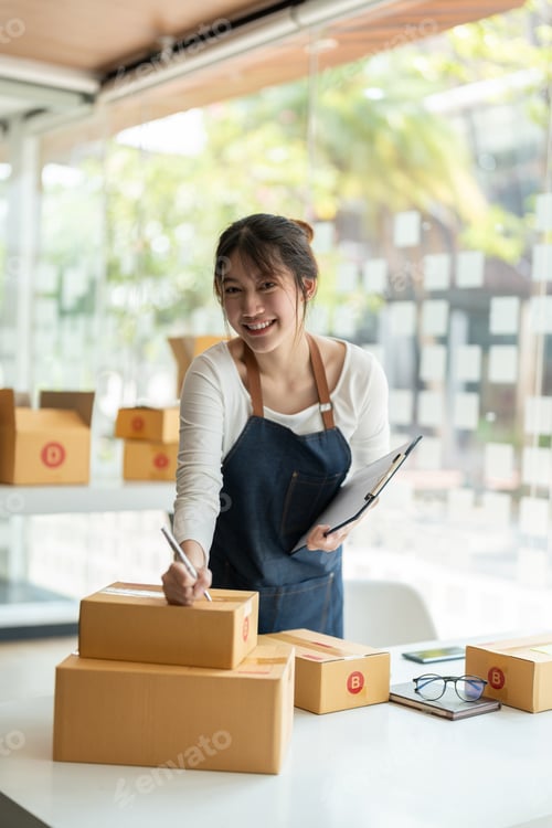 Preview: Portrait young attractive asia female owner startup look at camera work happy with box at home