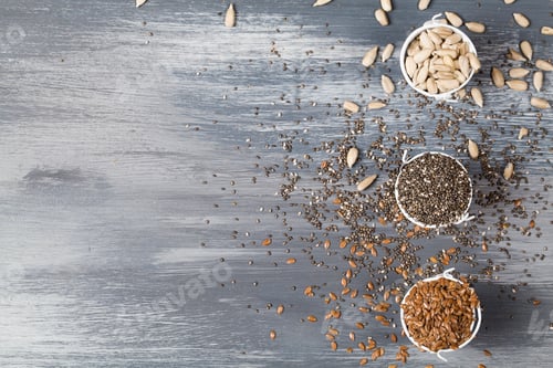 Preview: Healthy superfood sunflower seeds, flax seeds and chia on small pot on blue wooden background