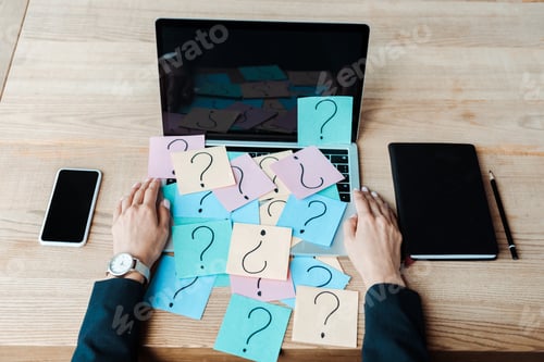 Preview: cropped view of woman near sticky notes with question marks on laptop