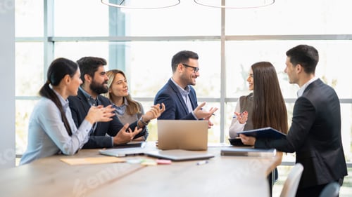 Preview: Businessman proposes promotion and congratulates young female colleague in front of team.
