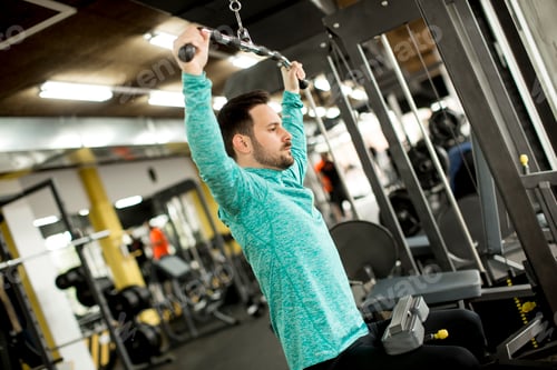 Preview: Man doing excersise on a lat machine in gym