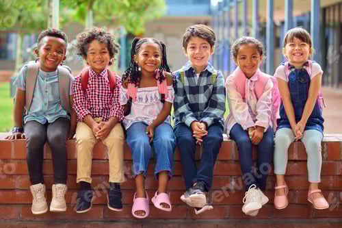 Visualização: Retrato de alunos multiculturais do ensino fundamental sentados na parede ao ar livre na escola