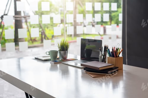 Preview: Office workplace with laptop and coffee and books and equipment on the desk.
