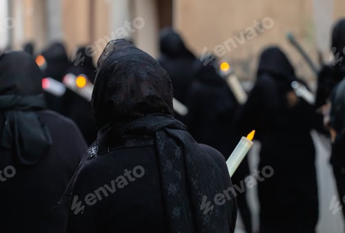 Preview: Hooded penitents carrying candles during a procession