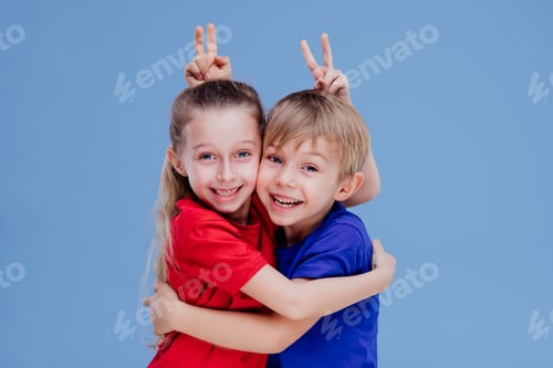 Preview: Happy siblings embracing and looking at camera
