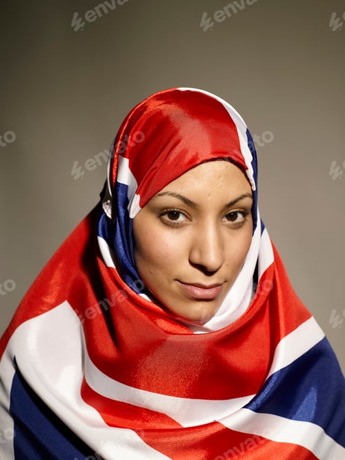 Preview: Portrait of a woman draped in a UK flag-patterned hijab, looking at the camera