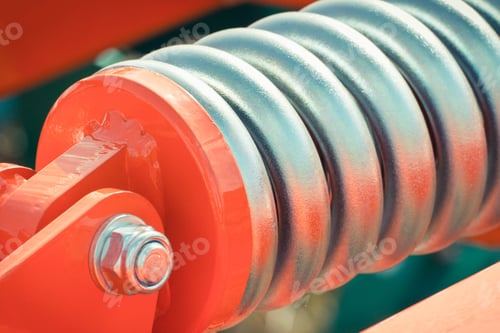 Preview: Big and hard steel silver spring as part and detail of red industrial or agricultural machine