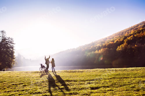 Preview: Senior couple with wheelchair in an autumn nature.