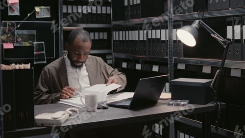 Preview: African american agent reading suspicious files in archive room