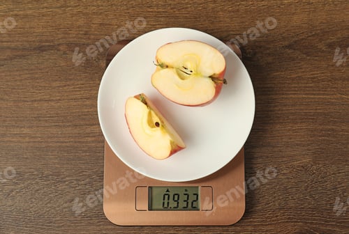 Preview: Modern electronic kitchen scale with cut apple on wooden table, top view