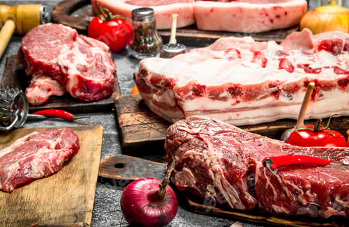 Preview: Different types of raw pork meat and beef with spices and herbs.