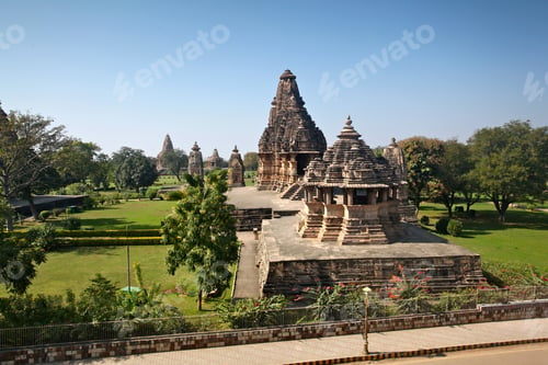 Preview: Horizontal shot of Khajuraho temples in India surrounded by beautiful green trees and flowers