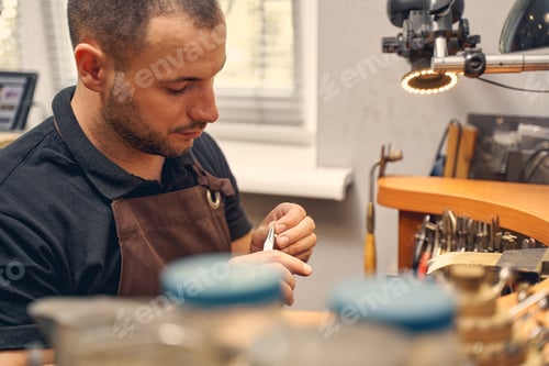 Preview: Serious young dark-haired man working in a shop