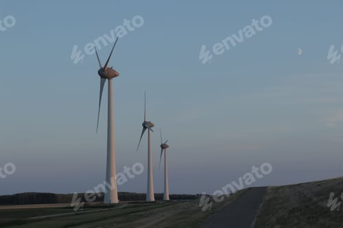 Preview: Beautiful shot of wind turbines in a landscape near water at sunset