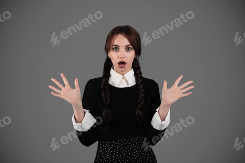 Preview: Shocked young girl student in gothic black clothes with pigtails with open mouth gesturing with