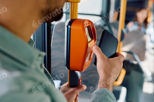 Preview: Close up of man using mobile phone while paying for a bus fare.