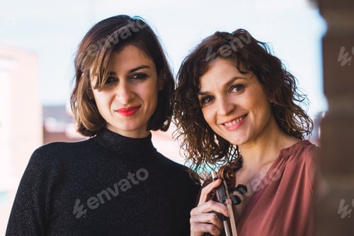 Preview: Young smiling women with violin on balcony