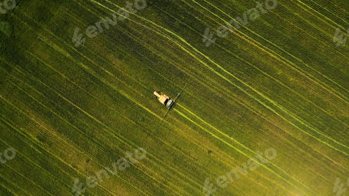 Preview: Overhead shot of a tractor treating an agricultural field during daylight