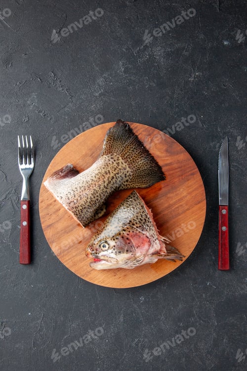 Preview: top view fresh sliced fish with fork and knife on a dark background seafood meal ocean sea meat food