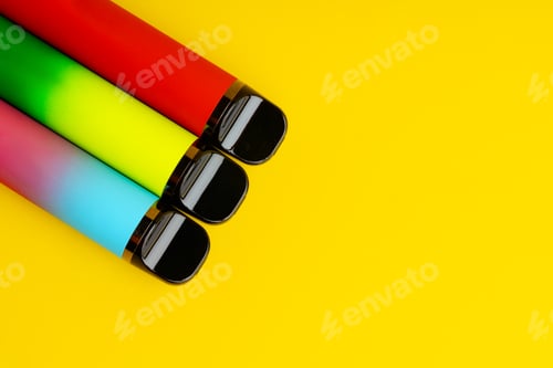Preview: Colorful disposable electronic cigarettes on yellow background