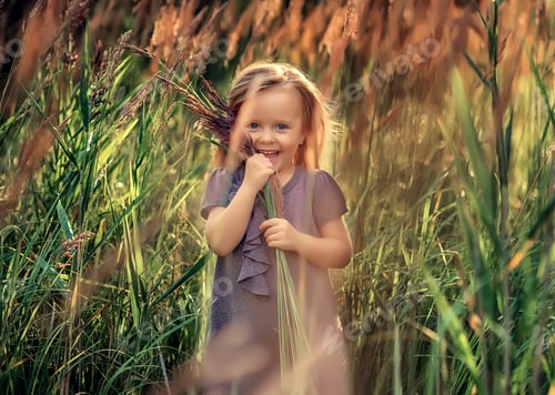 Preview: beautiful caucasian little girl stands in a field of herbs at summer sunset. Emotions
