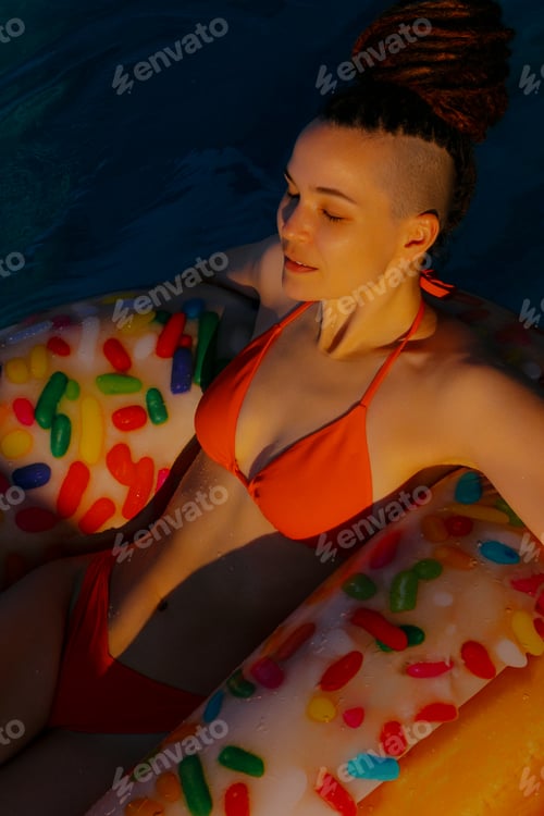 Preview: Woman with dreadlocks enjoys relaxing in pool. Hotel vacation