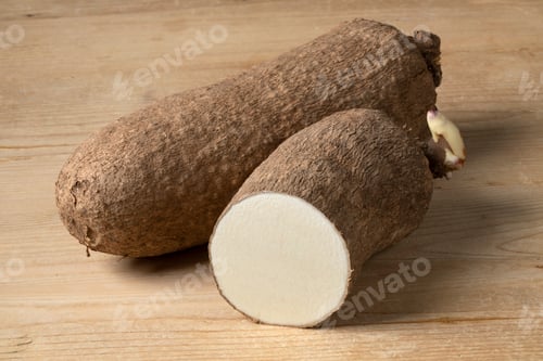 Preview: Whole and halved raw African yam on wooden background
