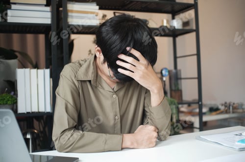 Preview: Overworked stressed businessman has headache pain while working in office.