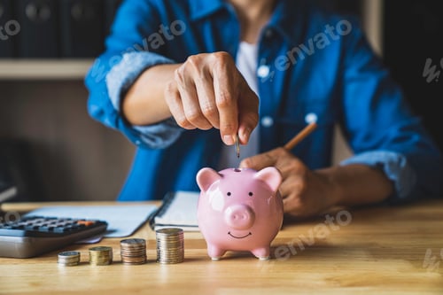 Preview: woman holds a coin in a pig-shaped piggy bank to save money for the future. after retirement and rec