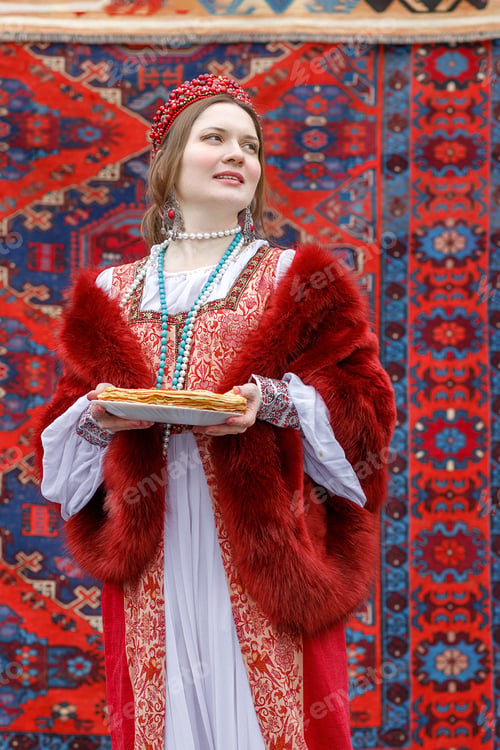 Preview: Woman holding a plate of pancakes with red caviar. Traditional thin Russian pancakes on a plate
