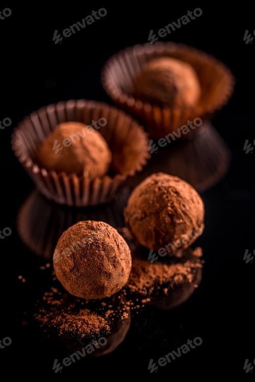 Chocolate Truffles in Paper Cups on Dark Surface