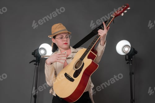 Preview: Woman Poses with Guitar in Studio Setting