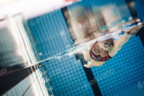 Preview: Female swimmer in action inside swimming pool