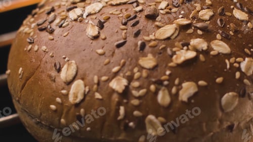 Preview: Burger bun being fried over fire. Stock footage. Close-up of round grain bun on grill. Bun for