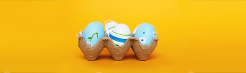 Preview: easter colorful handmade painted blue eggs in a box on orange background