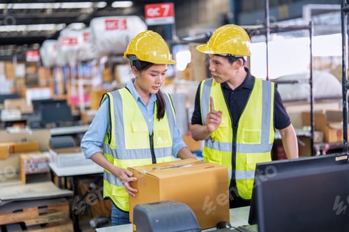 Preview: Staff working in large depot storage warehouse trainee check packing box and scan at cashier counter