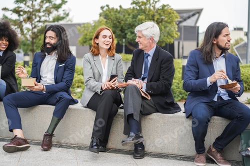 Preview: Business people from different ethnic and ages eating and chatting together outdoor at lunch break -