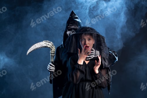 Preview: young female dressed in all black getting by deaths hand on dark surface grim reaper funeral