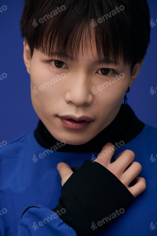Preview: Young handsome asian man showcasing style with a captivating gaze on a vibrant backdrop