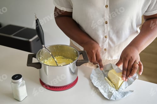 Preview: Young cuban woman frying mashed potatoes balls in a pan.