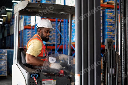 Preview: Forklift Truck Operator Lifts Pallet Cardboard Boxes On a Shelf by Trucks in Distribution Center