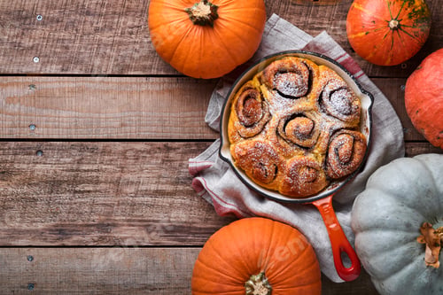 Preview: Cinnabon cinnamon rolls buns with pumpkin, nut, caramel and sugar cream iced on rustic wooden backgr