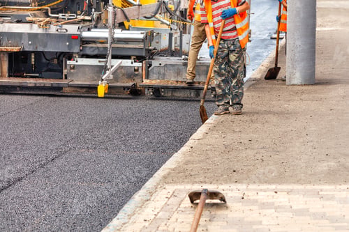 Preview: Paving fresh asphalt with industrial road equipment.