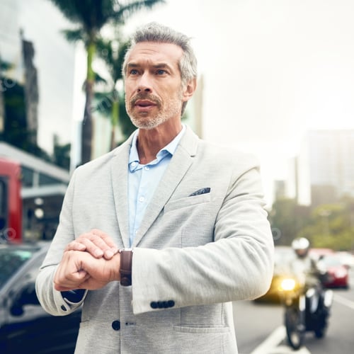 Preview: Shot of a mature businessman checking the time on his wrist watch out in the city