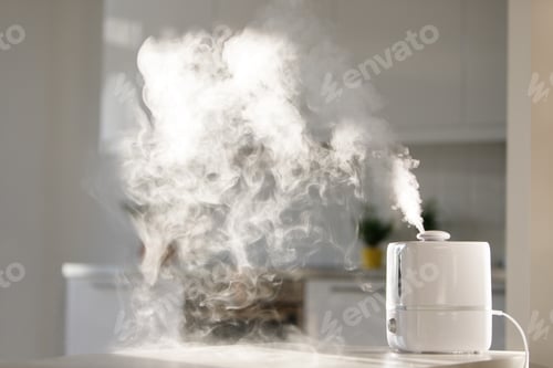 Preview: Close up of aroma oil diffuser on the table at home, steam from the air humidifier