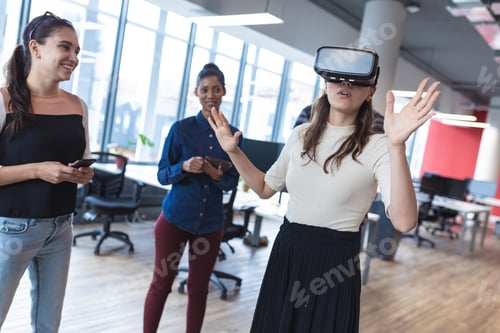 Preview: Diverse group of creative colleagues talking at meeting using vr headset